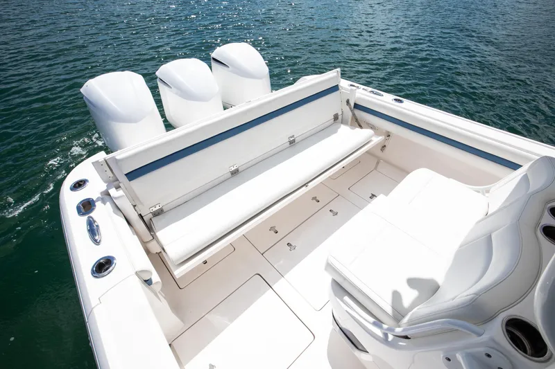 Slide: The Image of 2017 Intrepid 375 Center Console boat with white seating and triple engines on water. - 17