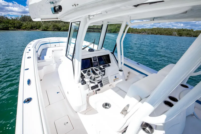 Slide: The Image of 2017 Intrepid 375 Center Console boat interior with helm, white seating, and ocean view. - 2