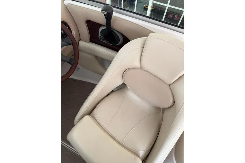 Slide: The Image of 2005 Chaparral Sunesta 236 boat interior with beige seating and steering wheel. - 9