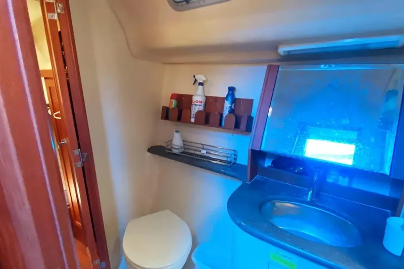 Slide: The Image of 2012 Hunter Aft Cockpit 50 yacht bathroom with sink, mirror, and storage shelves. - 17