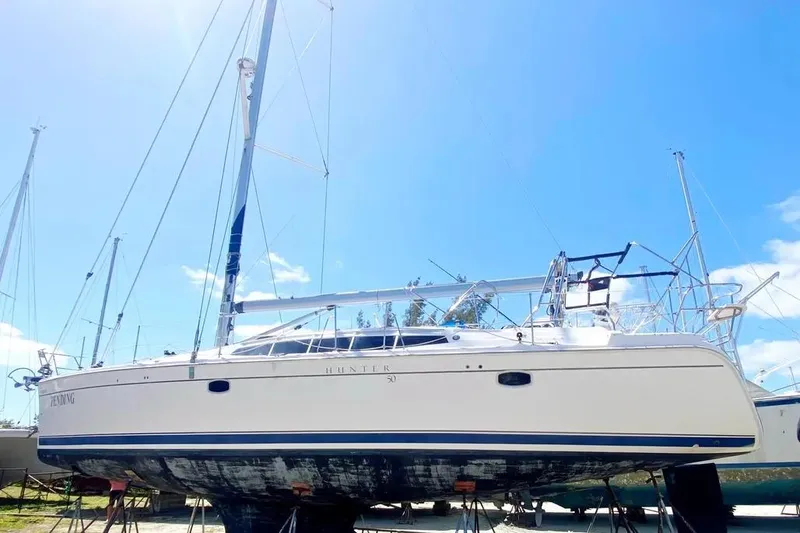 Slide: The Image of Hunter Aft Cockpit 50 sailboat, 2012 model, on land under clear blue sky. - 27