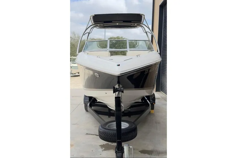 Slide: The Image of 2010 Colbalt 242 boat on trailer, parked outdoors, front view. - 10