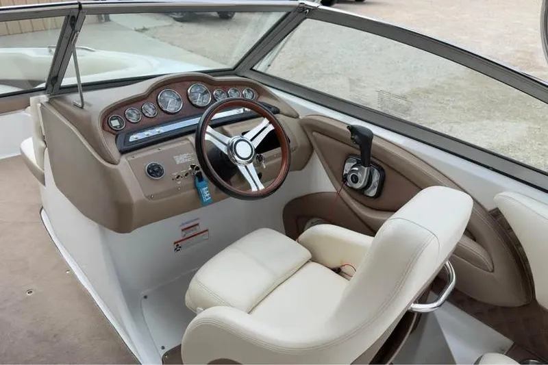 Slide: The Image of Interior of a 2010 Colbalt 242 boat, featuring a sleek dashboard and comfortable seating. - 13