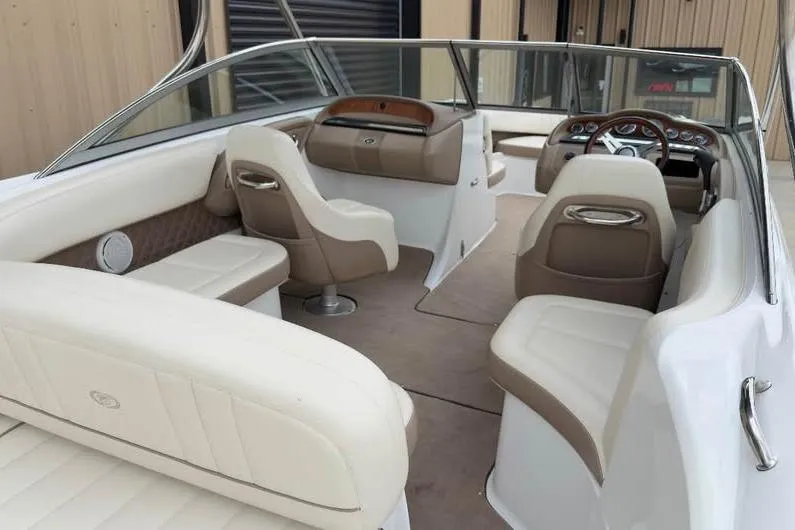 Slide: The Image of 2010 Colbalt 242 boat interior with beige and brown seating, steering wheel, and dashboard. - 3