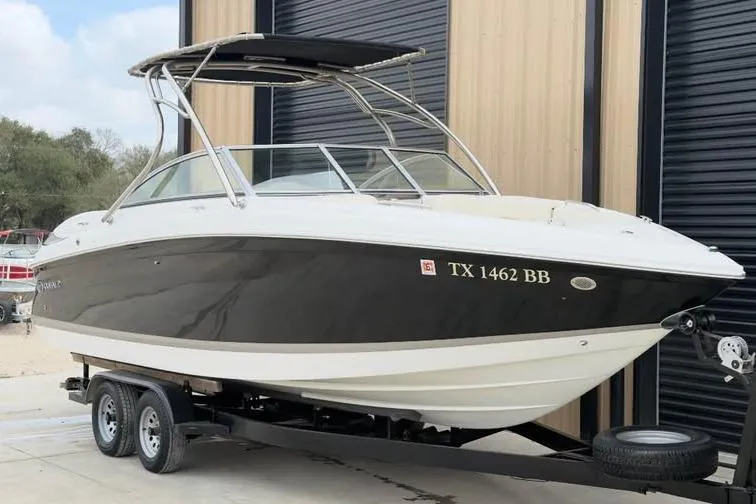 Slide: The Image of 2010 Colbalt 242 boat on trailer, black and white exterior, parked near a building. - 7