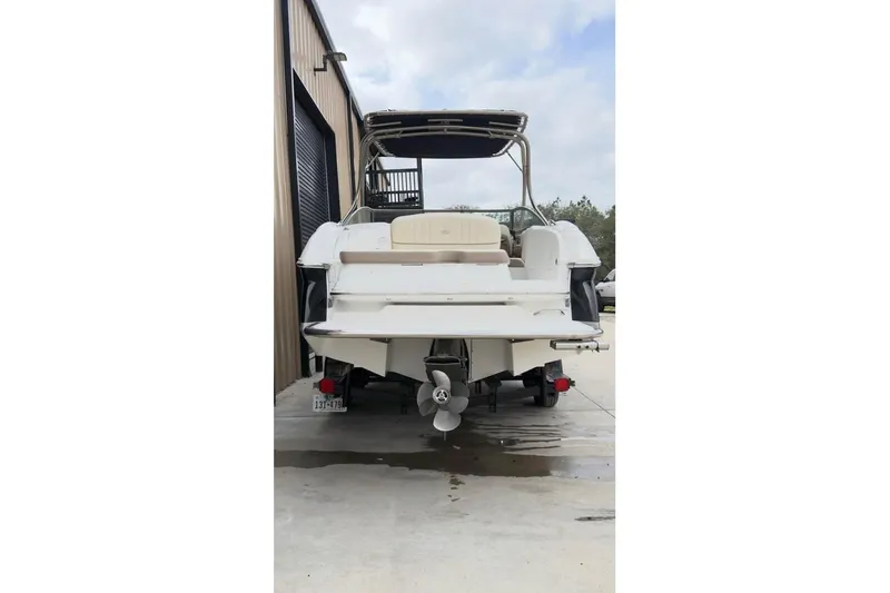 Slide: The Image of Rear view of a 2010 Colbalt 242 boat parked outside a building. - 8