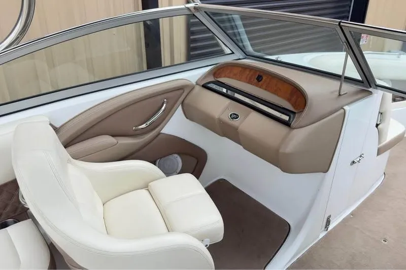 Slide: The Image of Interior of a 2010 Colbalt 242 boat with beige seating and dashboard. - 9