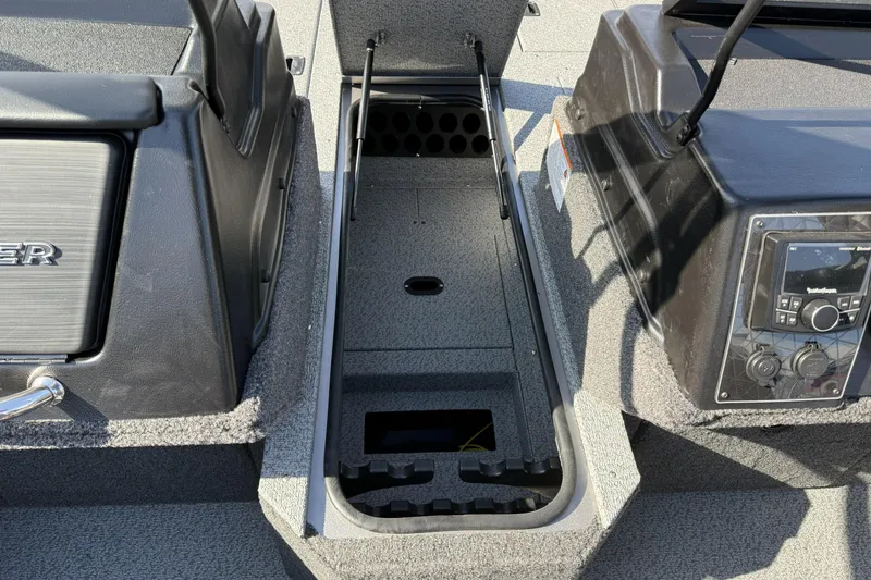 Slide: The Image of 2026 Crestliner 1850 Fish Hawk WT boat interior with open storage compartment and control panel. - 12