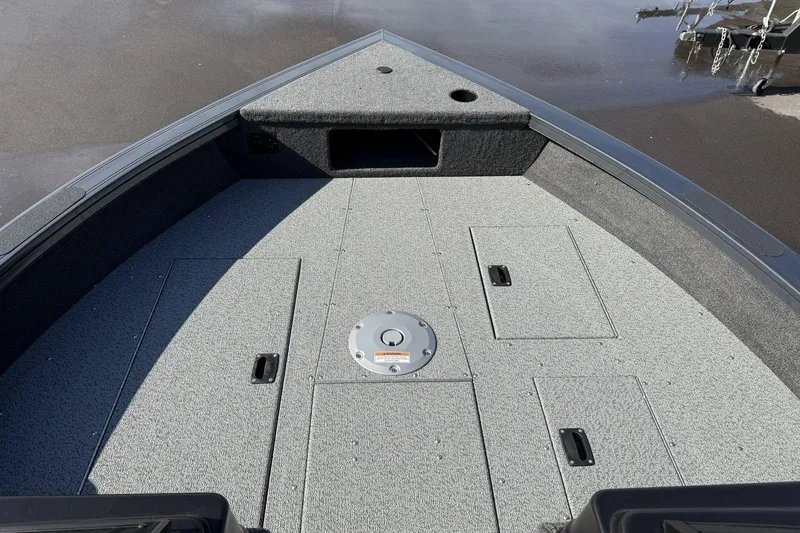 Slide: The Image of 2026 Crestliner 1850 Fish Hawk WT boat deck with storage compartments and gray carpeting. - 16