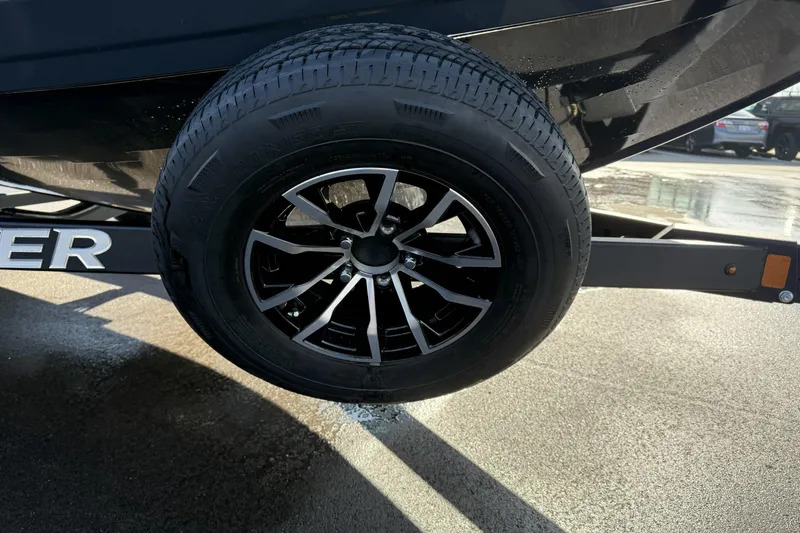 Slide: The Image of 2026 Crestliner 1850 Fish Hawk WT trailer wheel on wet pavement. - 18