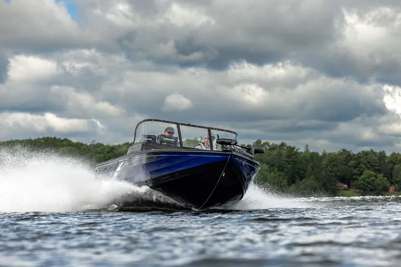 Slide: The Image of 2026 Crestliner 1850 Fish Hawk WT speeding on a lake under cloudy skies. - 22