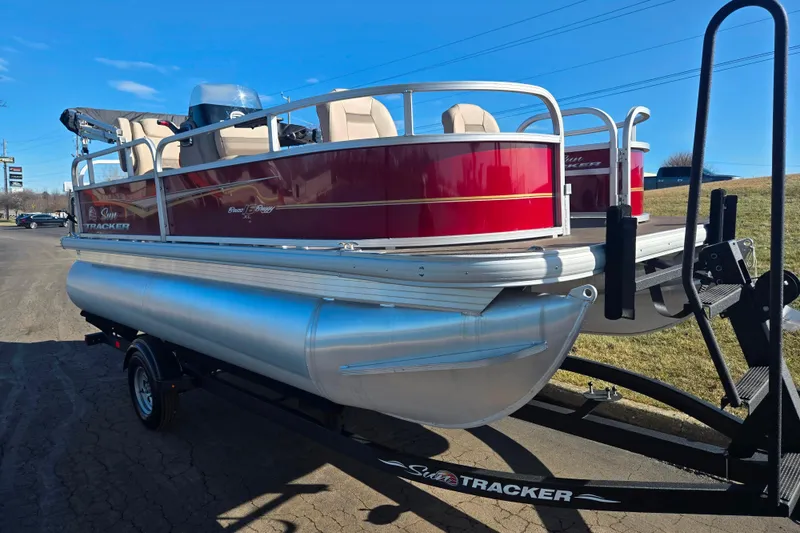 Slide: The Image of 2024 Sun Tracker Bass Buggy 16 XL Select pontoon boat on trailer, sunny day. - 5