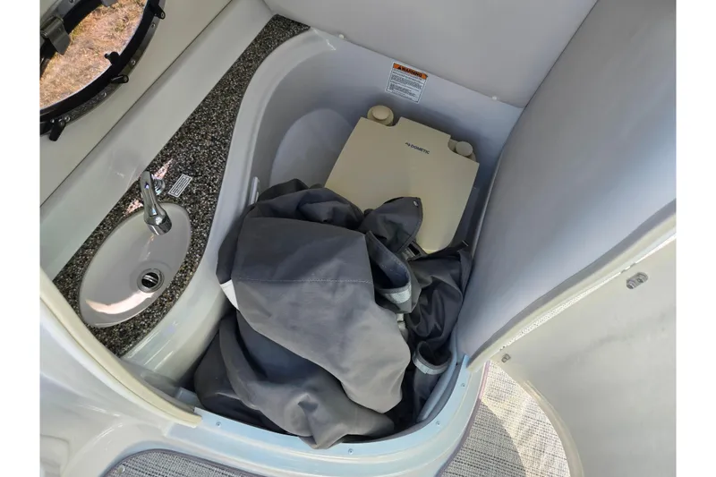 Slide: The Image of 2020 Crownline Eclipse E235 boat interior with sink and portable toilet. - 17