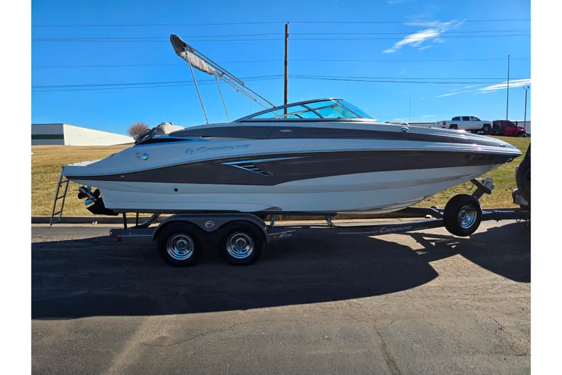 Slide: The Image of 2020 Crownline Eclipse E235 boat on trailer under clear blue sky. - 4