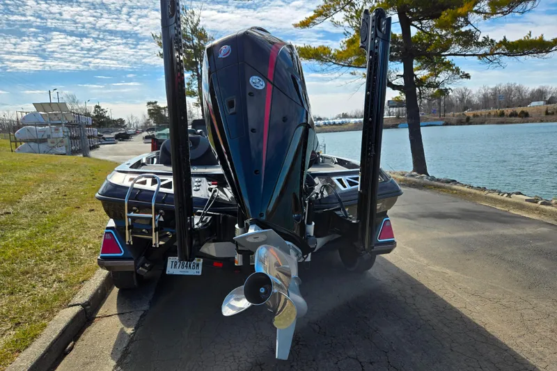 Slide: The Image of 2021 Ranger Z521L boat with powerful outboard motor by a scenic lakeside. - 2