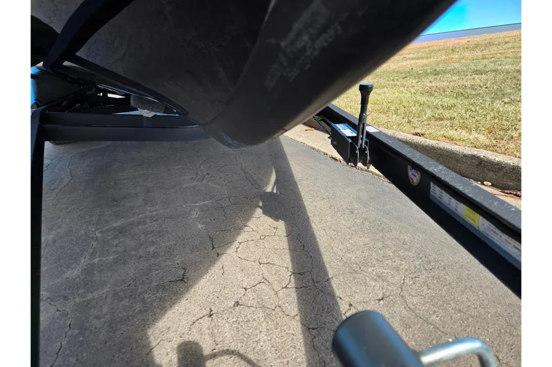 Slide: The Image of 2021 Ranger Z521L boat trailer on cracked pavement, grassy background. - 7