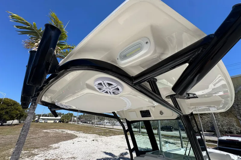 Slide: The Image of 2026 Sailfish 272 CC boat with T-top and speakers under clear blue sky. - 10
