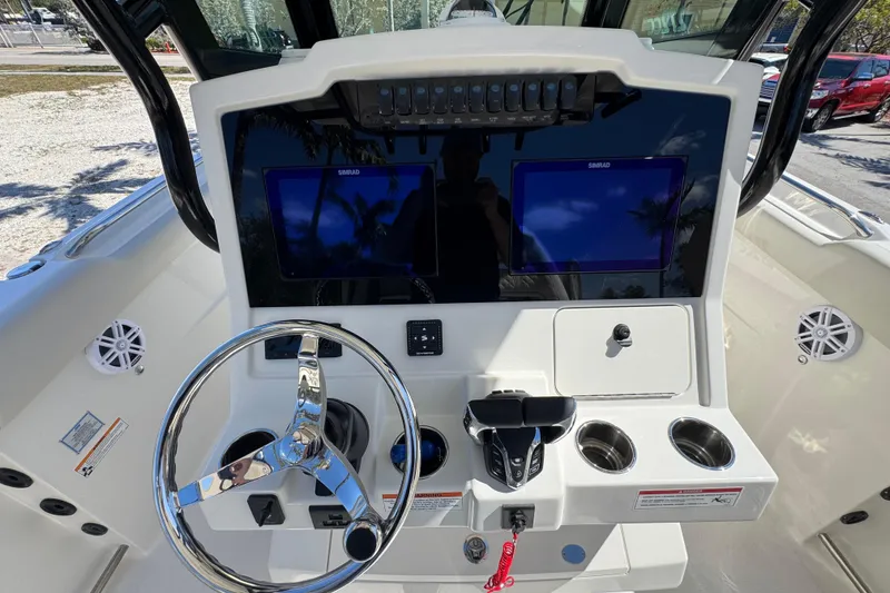 Slide: The Image of 2026 Sailfish 272 CC boat dashboard with dual Simrad displays and chrome steering wheel. - 6