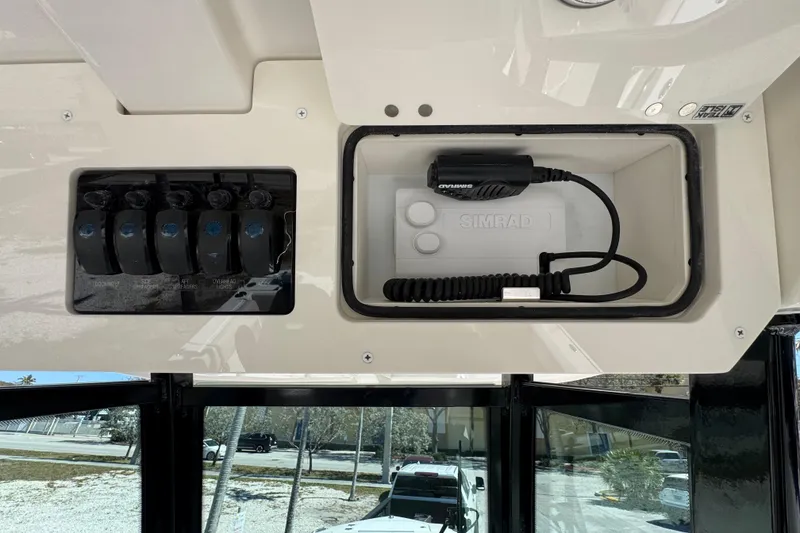 Slide: The Image of 2026 Sailfish 272 CC boat dashboard with Simrad radio and control switches. - 9