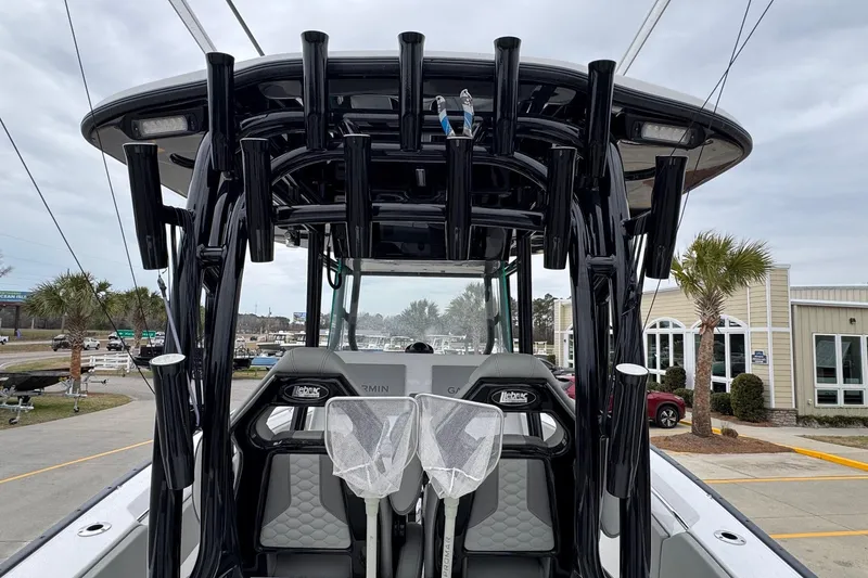 Slide: The Image of 2024 Cape Horn 32 XS boat with rod holders and seating, docked near a building. - 15