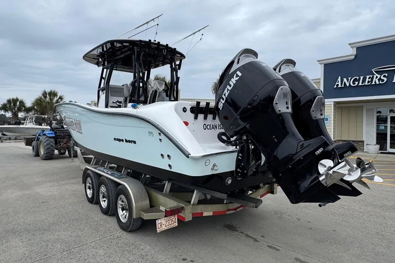 Slide: The Image of 2024 Cape Horn 32 XS boat with dual Suzuki engines on a trailer. - 2