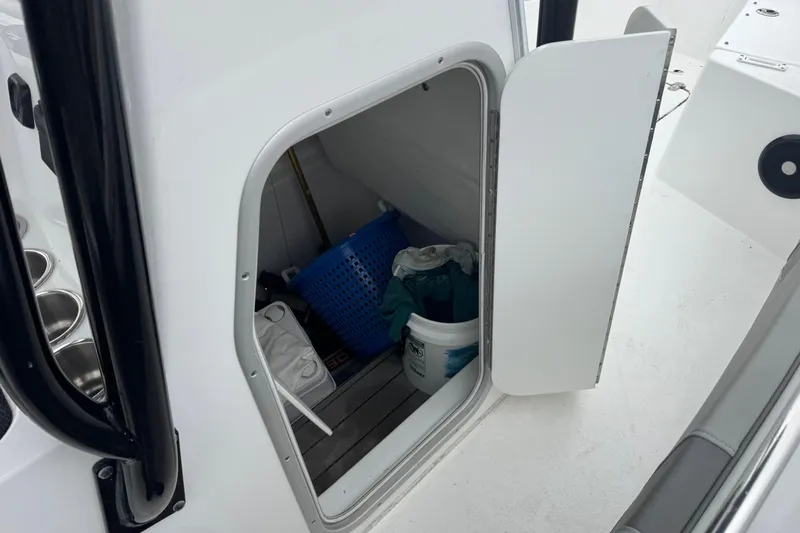 Slide: The Image of Storage compartment on 2024 Cape Horn 32 XS boat, containing cleaning supplies and a basket. - 6