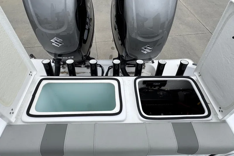 Slide: The Image of 2024 Cape Horn 32 XS boat with dual Suzuki outboard motors and open storage compartments. - 16