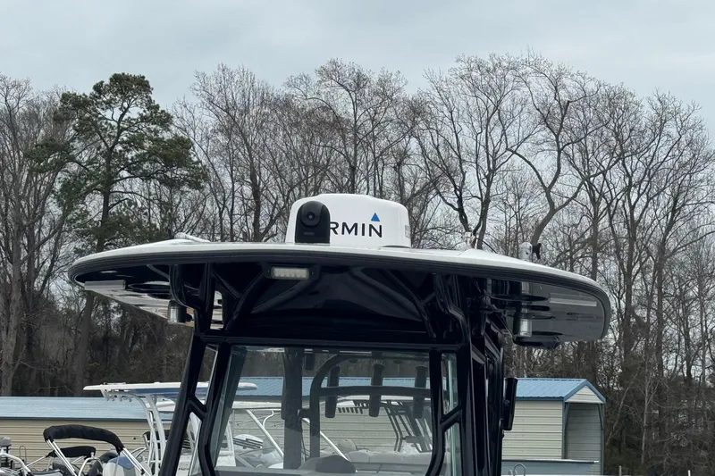 Slide: The Image of 2024 Cape Horn 32 XS boat with Garmin radar, surrounded by trees and overcast sky. - 18