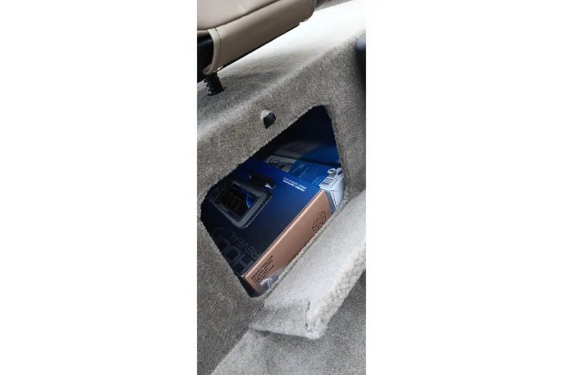 Slide: The Image of 2026 Tracker Bass Tracker Classic Limited storage compartment with electronic equipment box inside. - 14