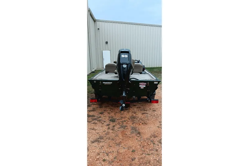 Slide: The Image of 2026 Tracker Bass Tracker Classic Limited boat with 50 HP motor, parked outdoors. - 19