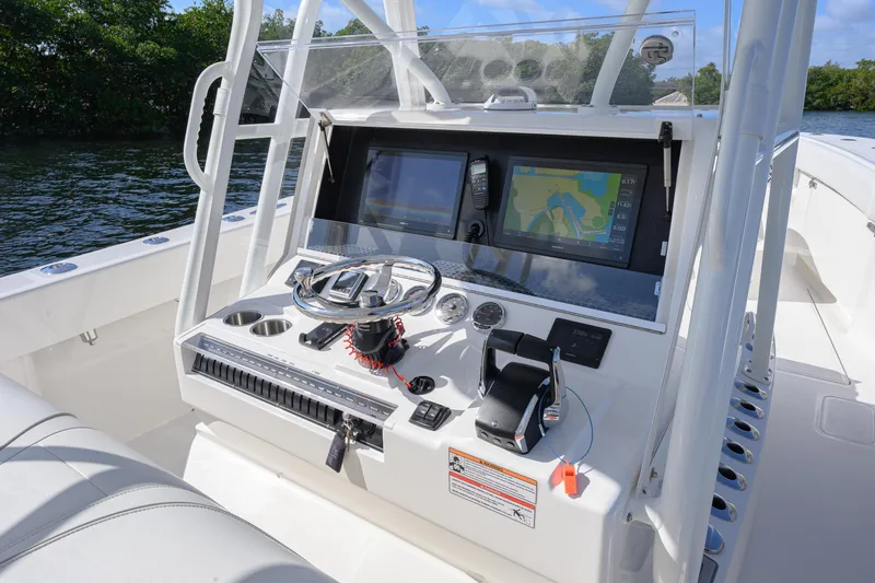 Slide: The Image of 2025 SeaVee 370Z boat console with navigation screens and controls on a sunny day. - 6