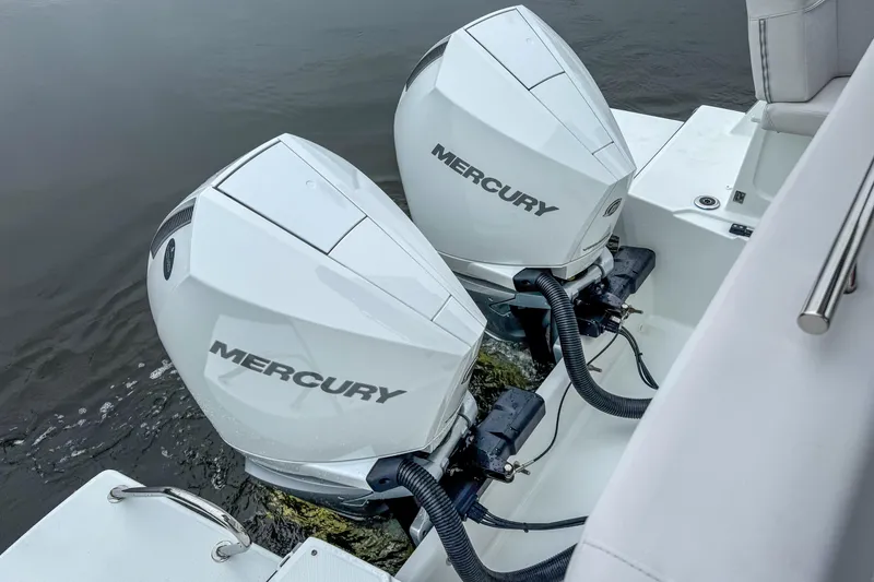 Slide: The Image of Twin Mercury outboard engines on a 2026 Beneteau Antares 11 boat, docked on calm water. - 43