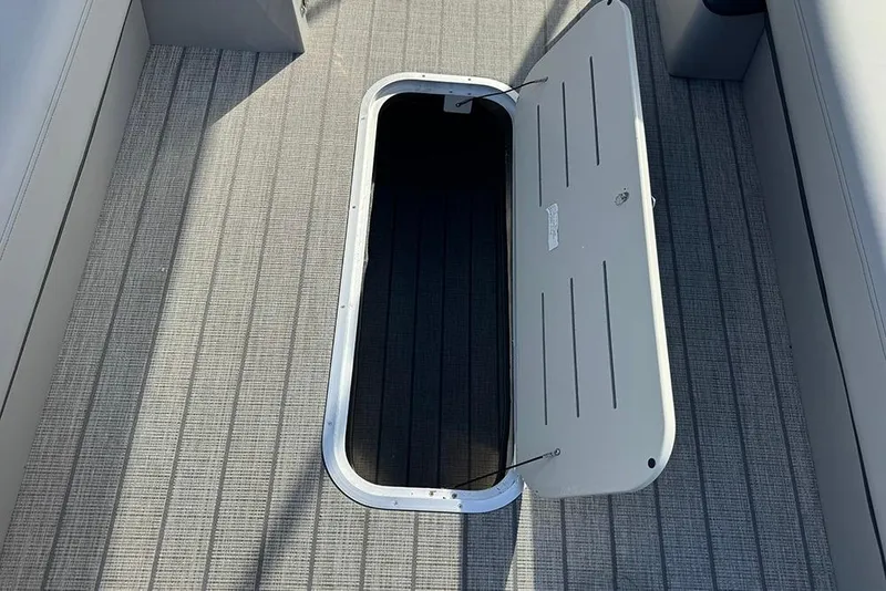 Slide: The Image of 2026 Bentley Pontoons Elite 253 Swingback storage compartment on textured deck. - 19