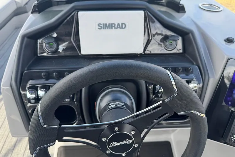 Slide: The Image of 2026 Bentley Pontoons Elite 253 dashboard with Simrad display and steering wheel. - 23