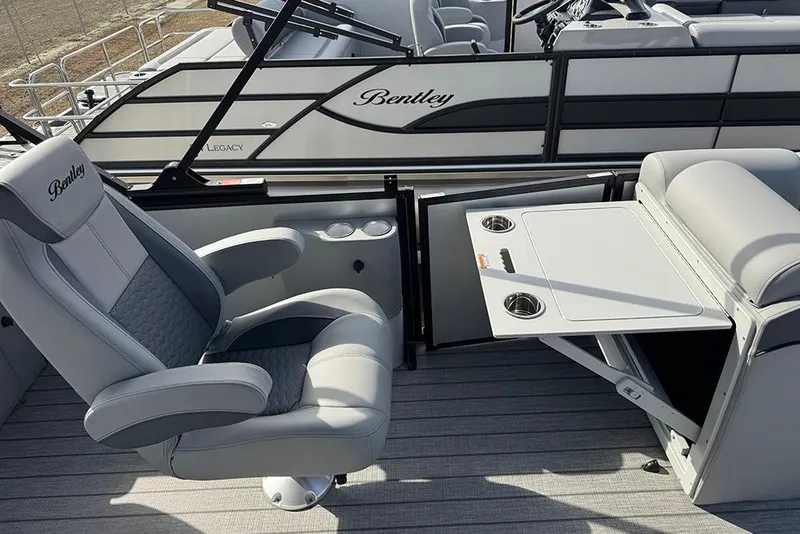 Slide: The Image of 2026 Bentley Pontoons Elite 253 interior with captain's chair and foldable table. - 29