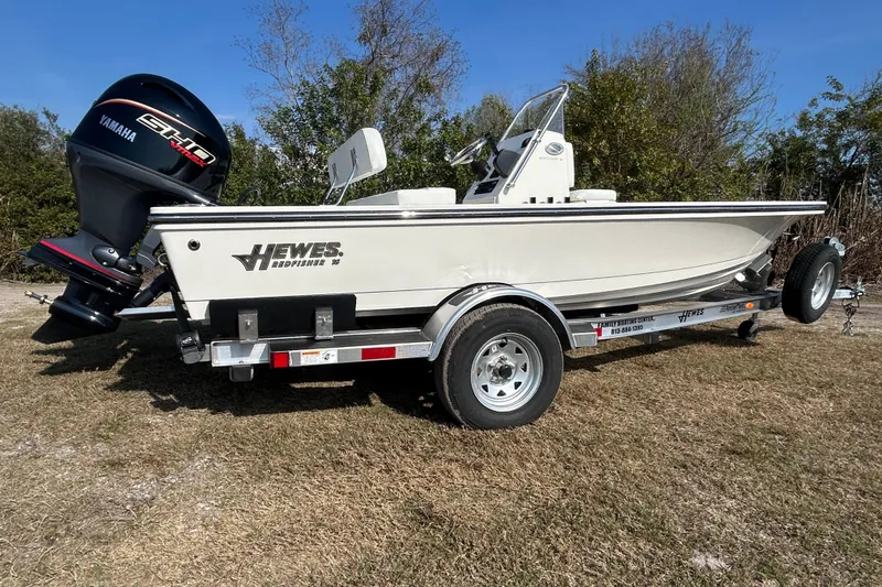 Slide: The Image of 2026 Hewes Redfisher 16 boat on trailer with Yamaha engine, parked on grass. - 5
