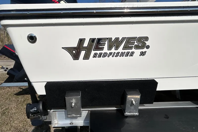 Slide: The Image of 2026 Hewes Redfisher 16 boat logo on white hull, close-up view. - 6