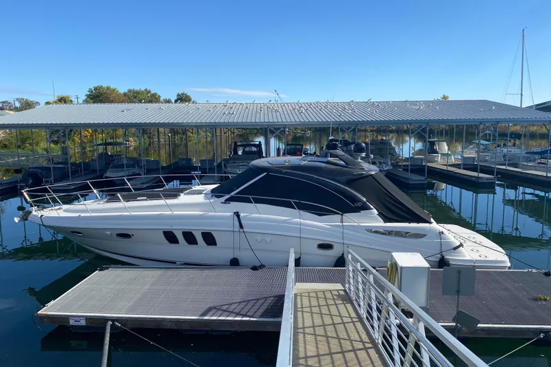The Image of 2008 Sea Ray 48 Sundancer yacht docked at marina under clear blue sky. - 0