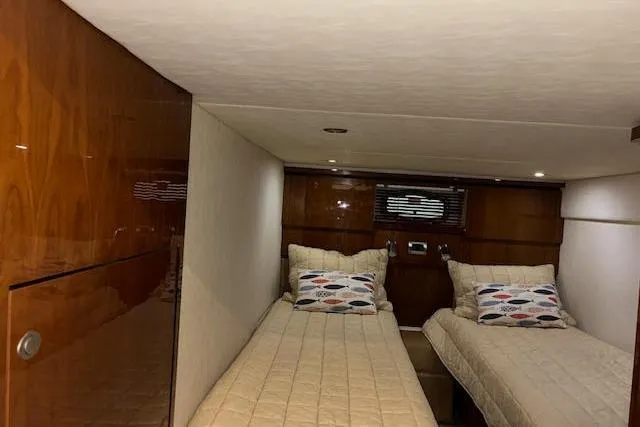 Slide: The Image of 2008 Sea Ray 48 Sundancer cabin with twin beds and wooden interior. - 12
