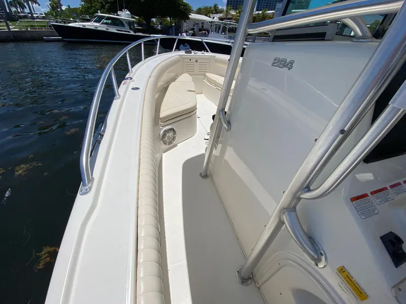 Slide: The Image of 2014 Mako 284 CC boat docked, showcasing sleek design and spacious deck. - 12