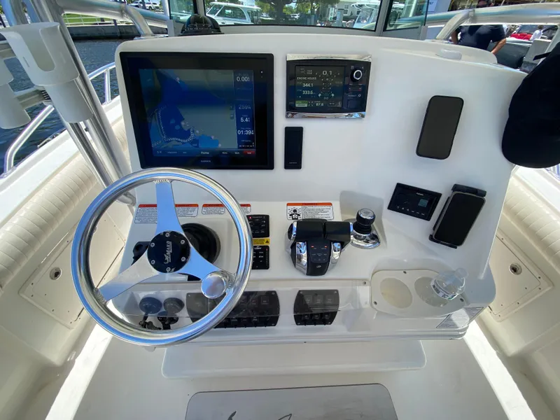 Slide: The Image of Control panel of a 2014 Mako 284 CC boat with steering wheel and navigation screens. - 17