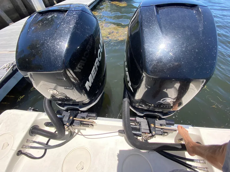 Slide: The Image of Twin Mercury outboard engines on a 2014 Mako 284 CC boat at a dock. - 20