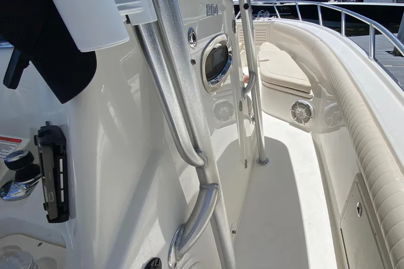 Slide: The Image of 2014 Mako 284 CC boat interior with stainless steel railings and cushioned seating. - 22