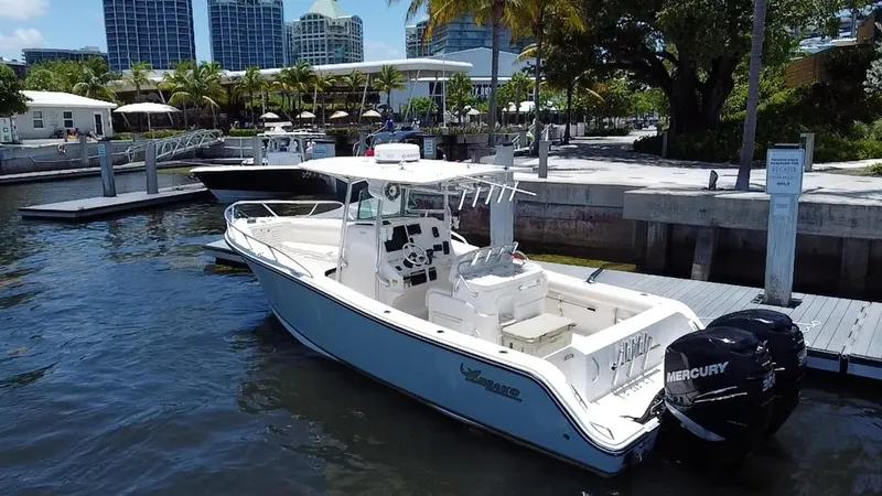 Slide: The Image of 2014 Mako 284 CC boat docked at a marina with Mercury engines. - 6