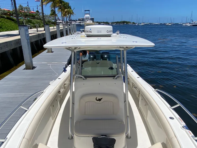 Slide: The Image of 2014 Mako 284 CC boat docked by a scenic waterfront. - 7