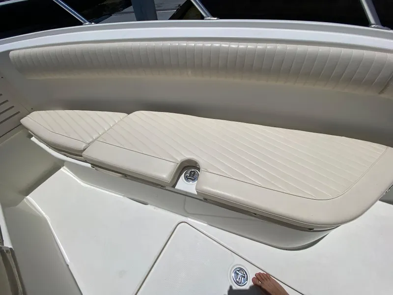 Slide: The Image of 2014 Mako 284 CC boat interior with cushioned seating and sleek design. - 9