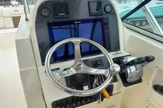 Slide: The Image of 2010 World Cat 290 DC boat dashboard with steering wheel and navigation controls. - 11