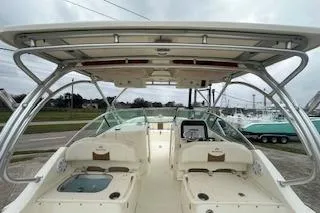 Slide: The Image of 2010 World Cat 290 DC boat interior with seating and helm, under a sturdy canopy. - 13