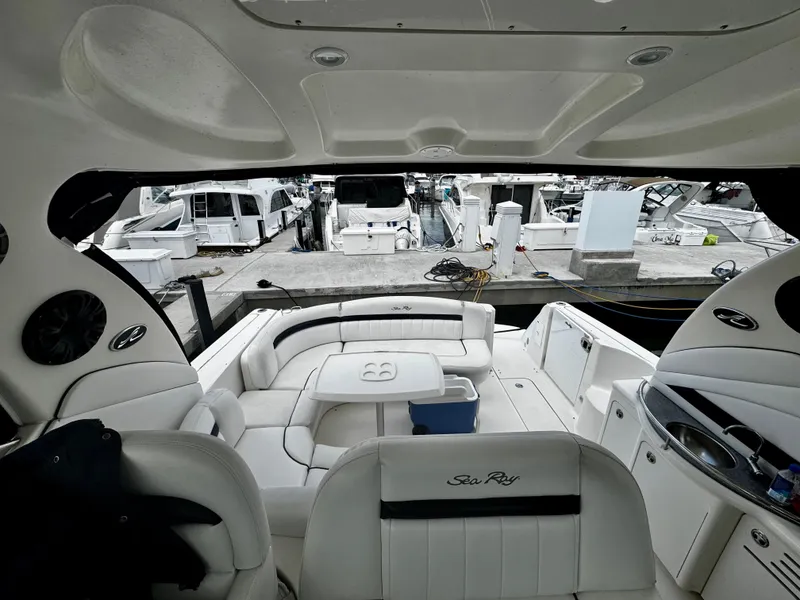 Slide: The Image of 2007 Sea Ray 40 Sundancer yacht interior with white seating and docked boats in background. - 9