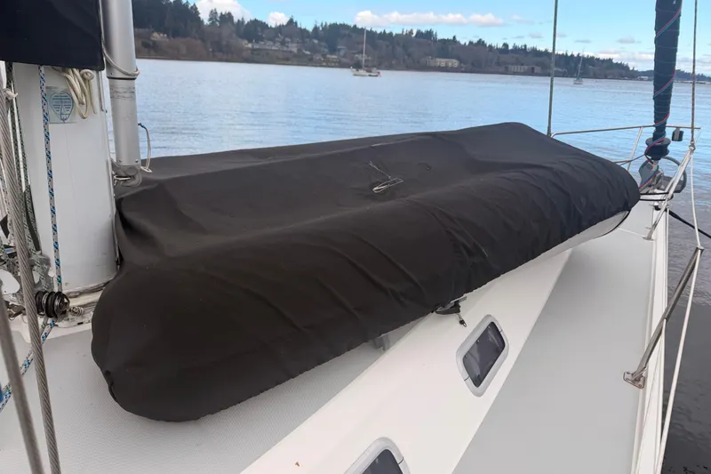 Slide: The Image of 1989 Catalina 42 sailboat deck with covered equipment, moored on a calm lake. - 13
